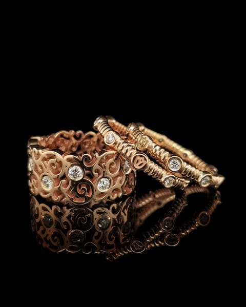 Rosé gouden ring met krulwerk en diamanten, met twee dunne gedraaide ringen.